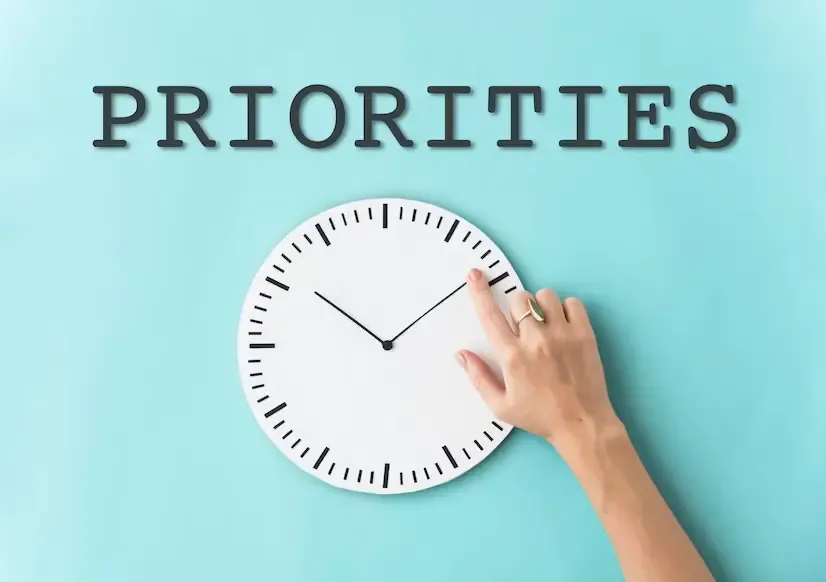 Determine-Your-Priorities The word PRIORITIES spelled out above a wall clock