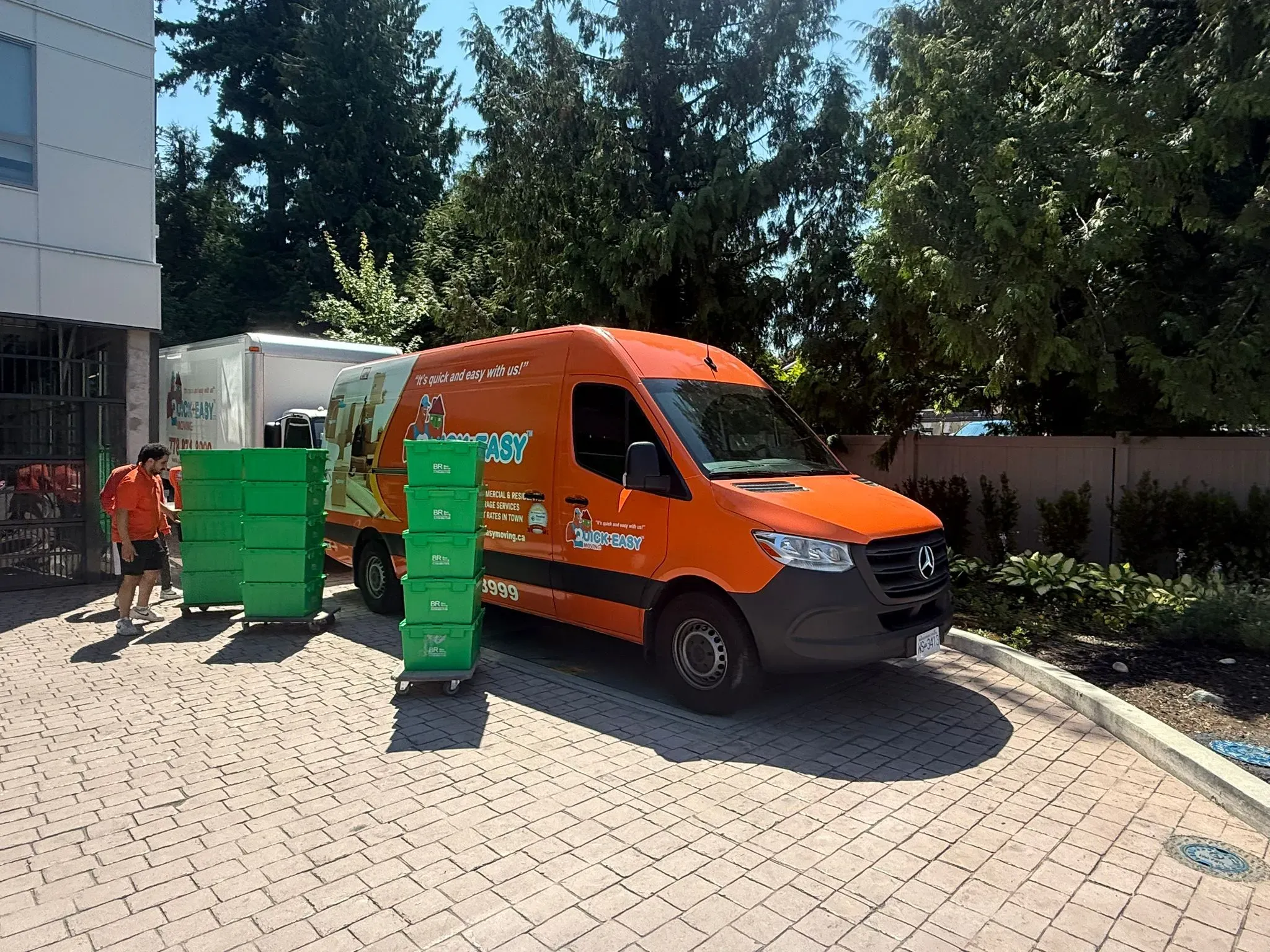 Orange Quick & Easy van with stacks of green storage bins